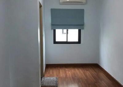 Small bedroom with wooden flooring and air conditioning