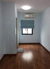 Small bedroom with wooden flooring and air conditioning