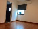 Bedroom with wooden flooring and a window with a blind