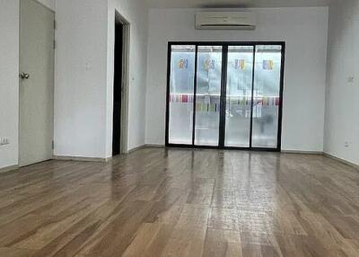 Spacious living room with wooden flooring and a large window