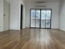 Spacious living room with wooden flooring and a large window