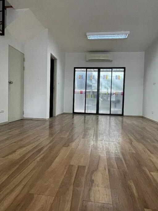 Spacious living room with wooden flooring and a large window