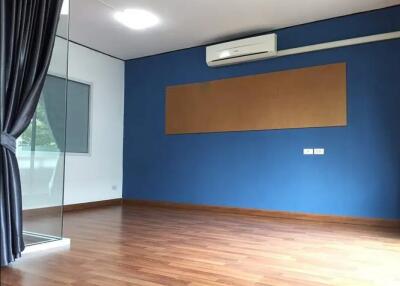 Empty living room with wooden flooring and blue accent wall