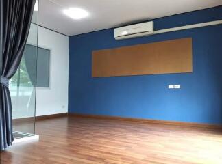 Empty living room with wooden flooring and blue accent wall