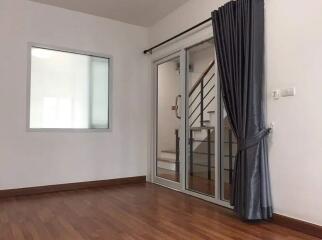 Spacious living room with wooden flooring and large window