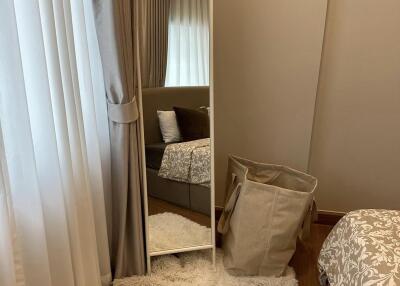 Stylish bedroom with full-length mirror and soft furnishings