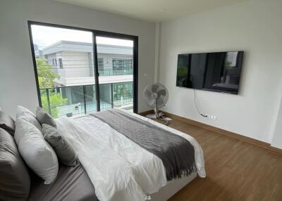 Spacious bedroom with large window and mounted TV