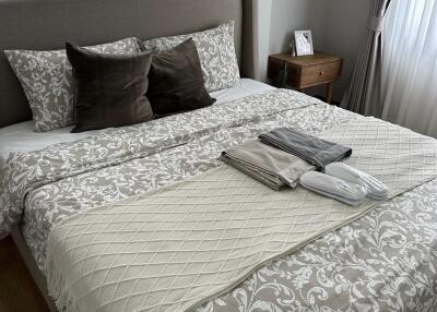 Cozy bedroom with a well-decorated bed featuring floral bedding and multiple pillows