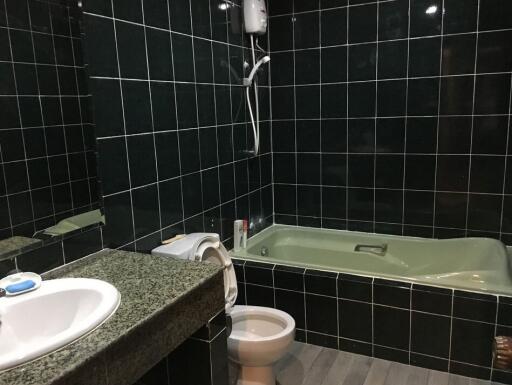 Bathroom with tiles, bathtub, toilet, and sink