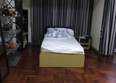 Bedroom with bed, shelves, and striped curtains