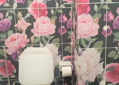 Bathroom with floral wall tiles and toilet