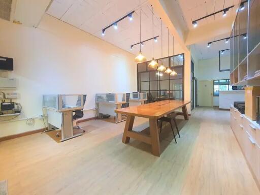 Modern office space with long wooden table and workstations