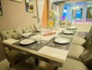 elegantly set dining table with chairs and decor in a brightly lit room