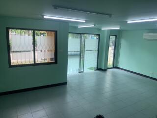 Spacious living room with large windows and tiled floor