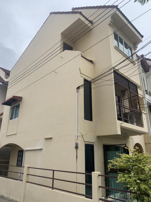 Exterior view of a multi-story building with a small balcony and gate