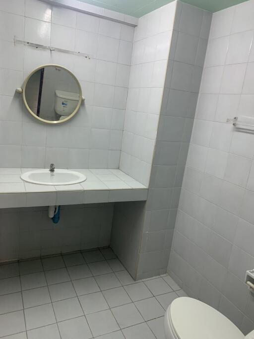 Simple bathroom with white tiles and round mirror