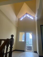 Staircase leading to a balcony with a high ceiling and natural light