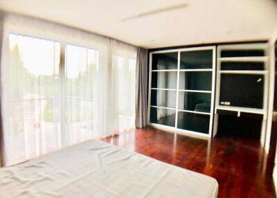 Spacious bedroom with large windows and built-in wardrobe