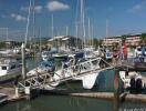 marina with several boats docked and people walking on a bridge