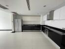 Modern kitchen with black and white cabinetry and stainless steel appliances