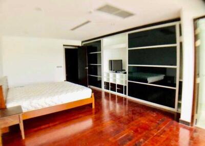 Spacious bedroom with wooden flooring and built-in storage