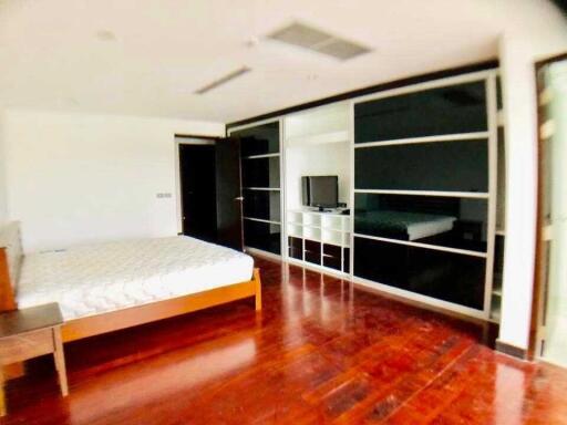 Spacious bedroom with wooden flooring and built-in storage