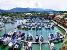 Scenic view of a marina with multiple boats docked, surrounded by buildings and hills