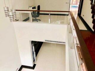 Modern multi-level interior with railing and office area