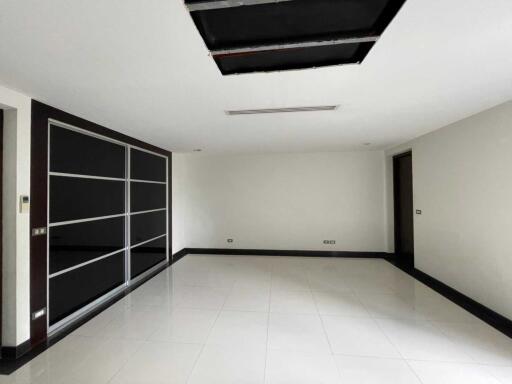 Spacious living room with large windows and tiled floor