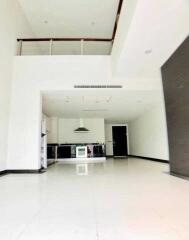 Modern main living area with loft, high ceilings, and kitchen