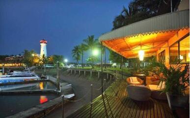 Outdoor deck area by the waterfront with seating and nearby lighthouse