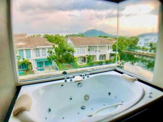 Bathroom with a window view of neighboring houses and greenery