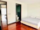 Spacious bedroom with ensuite bathroom and wooden flooring