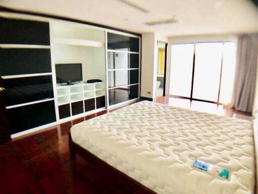 Spacious bedroom with large window and built-in storage