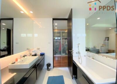 Modern bathroom with bathtub, sink, and large mirror