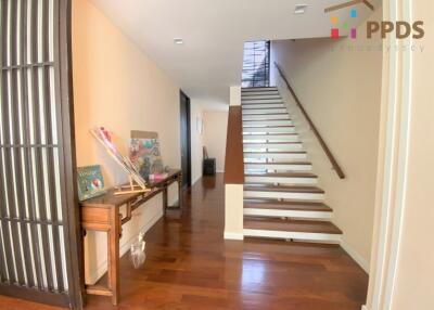 Bright hallway with wooden flooring and stairway