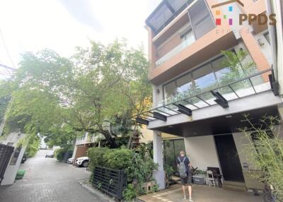 Front view of a residential building with street-side greenery