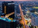 Cityscape view with illuminated buildings and busy streets at dusk.