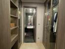 Walk-in closet with shelves, glass-front cabinets, and an en-suite bathroom