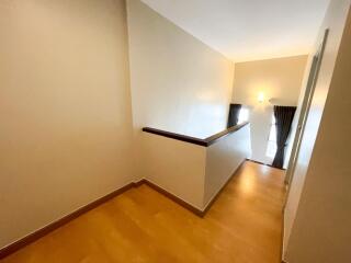 Bright hallway with wooden flooring and wall sconce