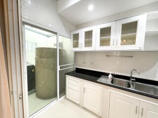 Bright kitchen with white cabinetry and black countertops