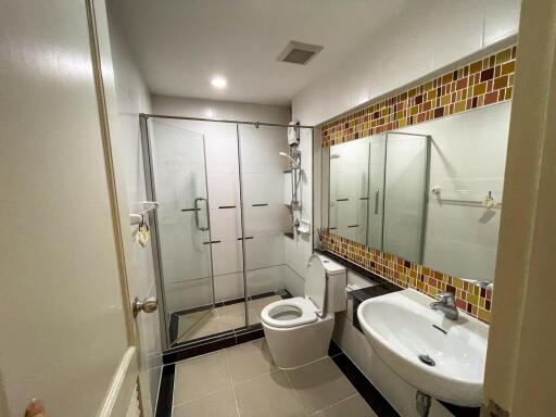 Modern bathroom with glass shower, toilet, and sink