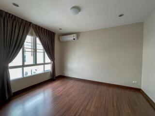 Empty bedroom with wooden flooring and large window