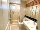 Modern bathroom with glass shower, large mirror, and white fixtures