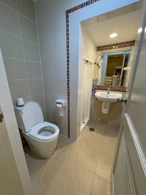 Modern bathroom with toilet, sink, and shower area