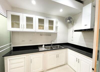 Modern white kitchen with black countertops and cabinets