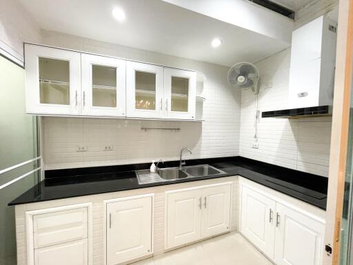 Modern white kitchen with black countertops and cabinets