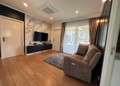 Modern living room with wooden flooring and wall-mounted TV