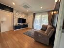 Modern living room with wooden flooring and wall-mounted TV