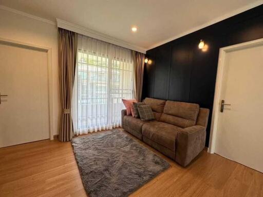 Cozy living room with a large window, sofa, and a rug